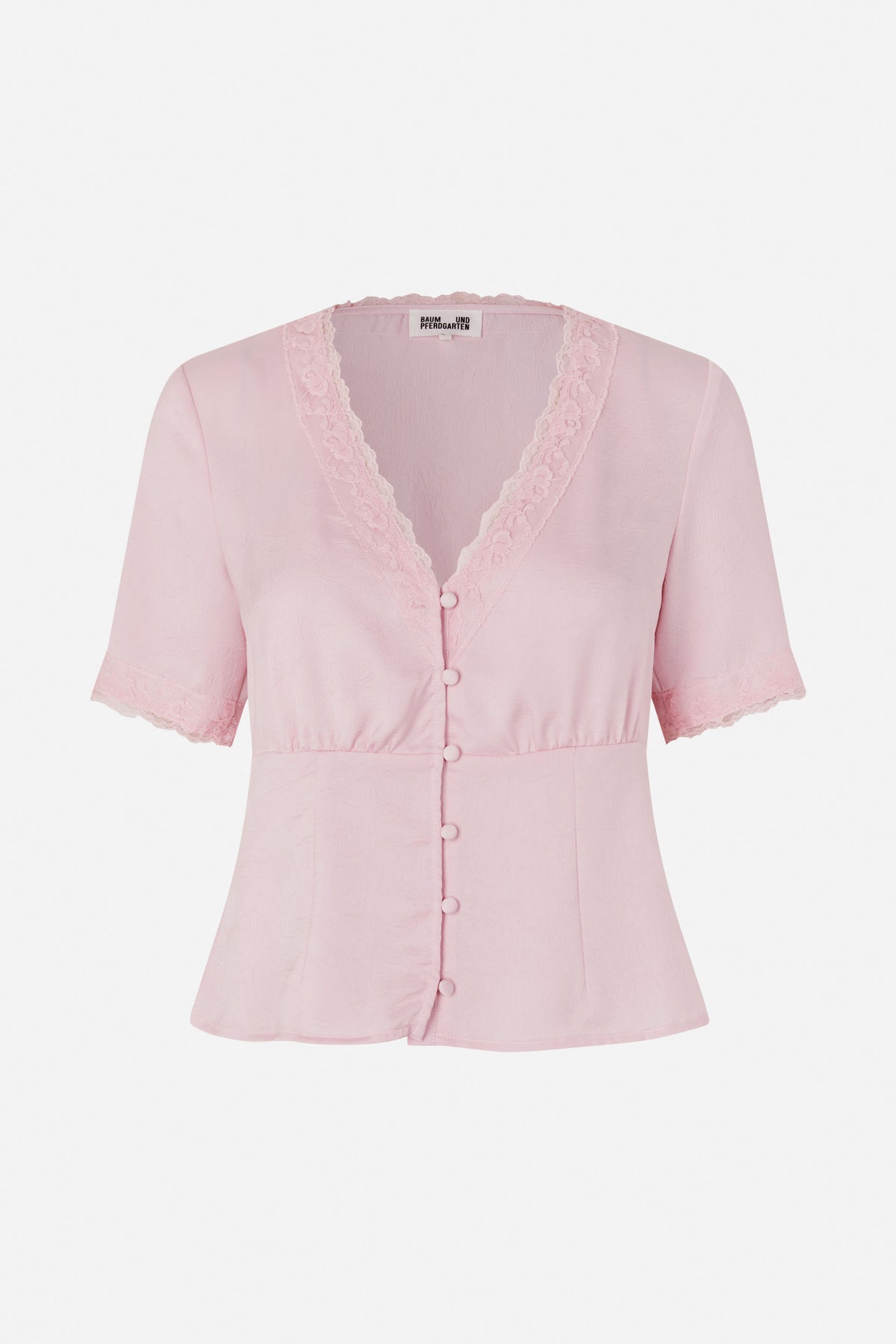 Front view of a pale pink short-sleeved blouse with a lace-trimmed V-neck, matching covered buttons and lace sleeve hems.
