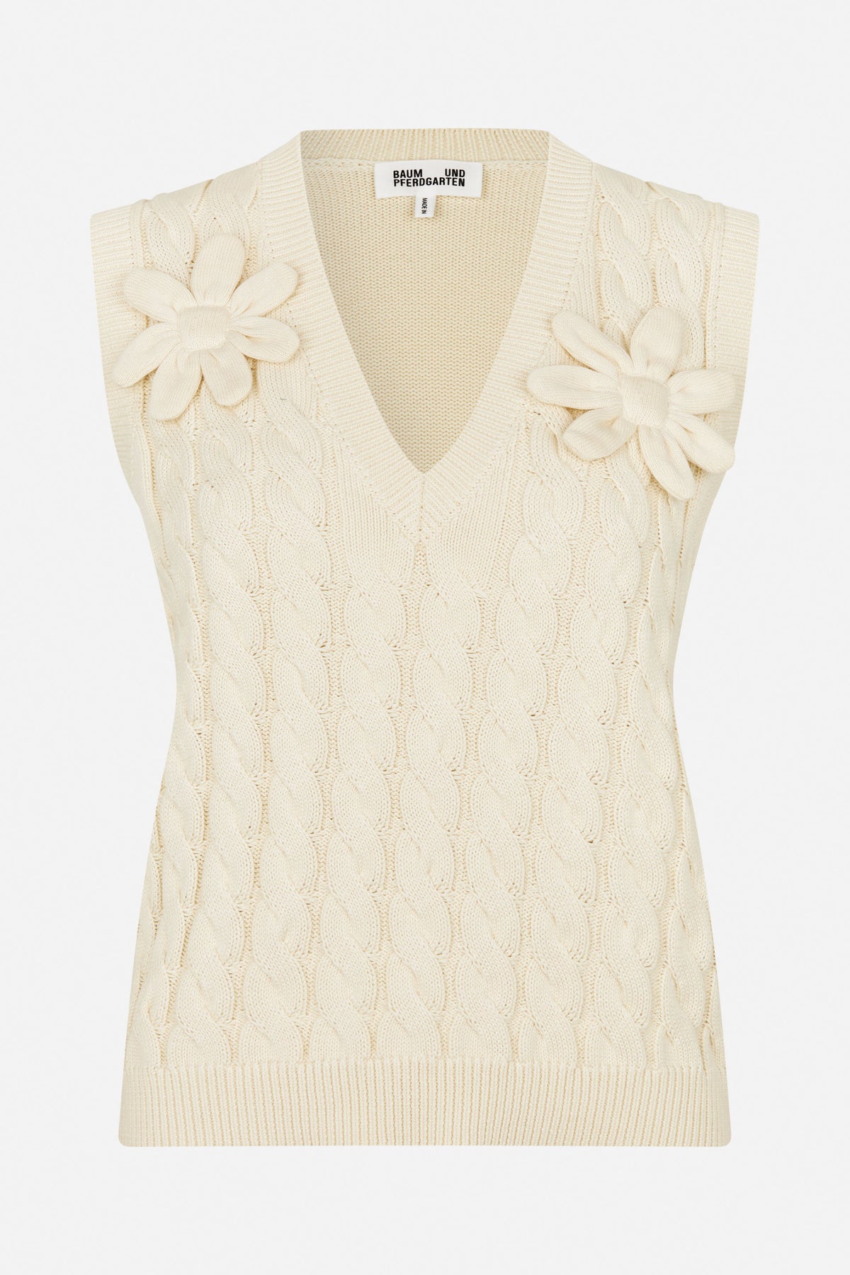 Front view of an ivory knitted sleeveless vest with a V-neck, cable pattern and raised flower details at the shoulders.