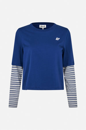 Front view of a blue short-sleeve T-shirt layered over a white top with navy horizontal stripes and a small white chest logo.