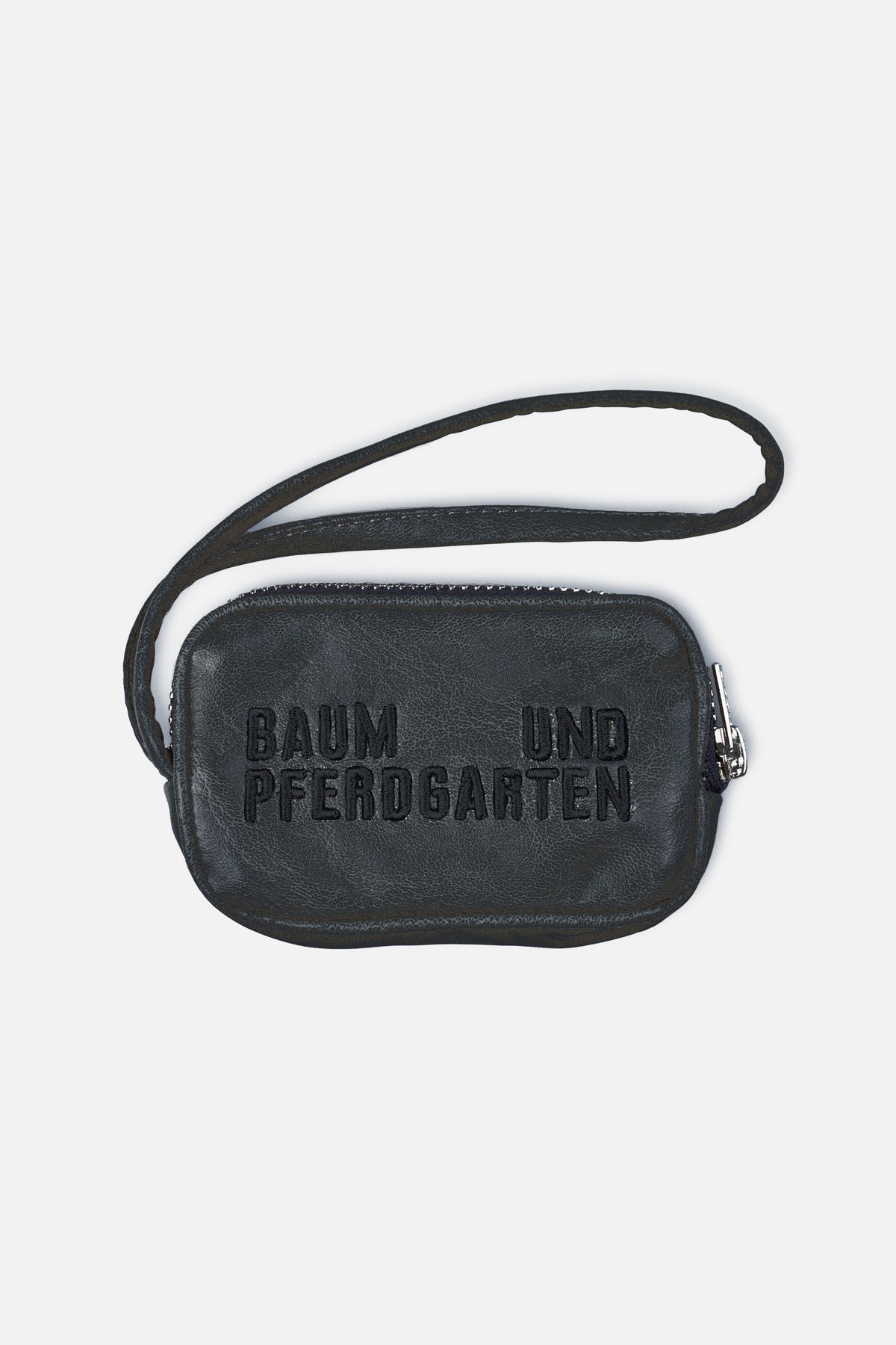 Black pebbled crossbody bag with a long strap, silver-tone zipper and raised Baum und Pferdgarten lettering on the front.