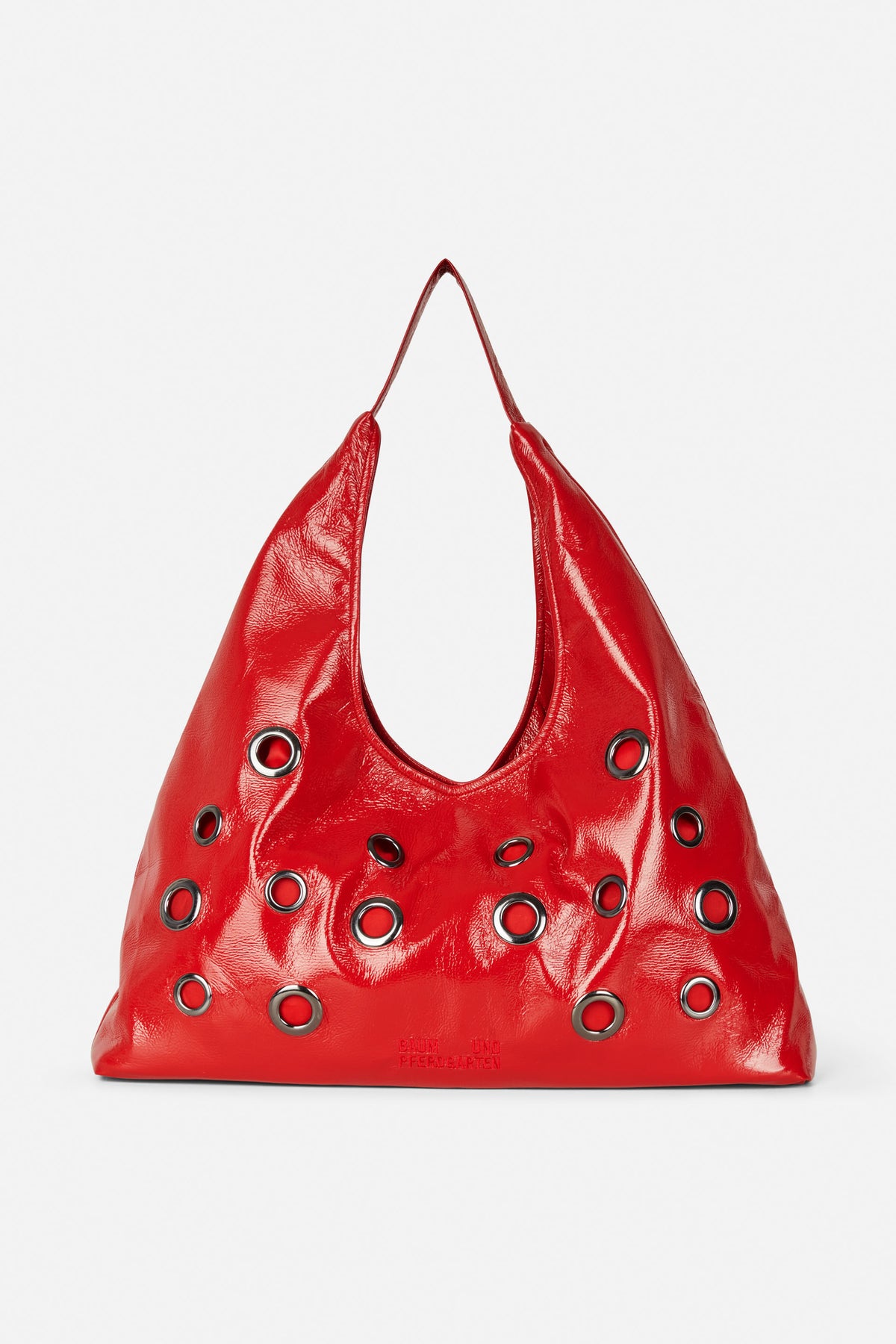 Glossy red shoulder bag with a single strap and multiple silver-tone grommets, shown from the front.