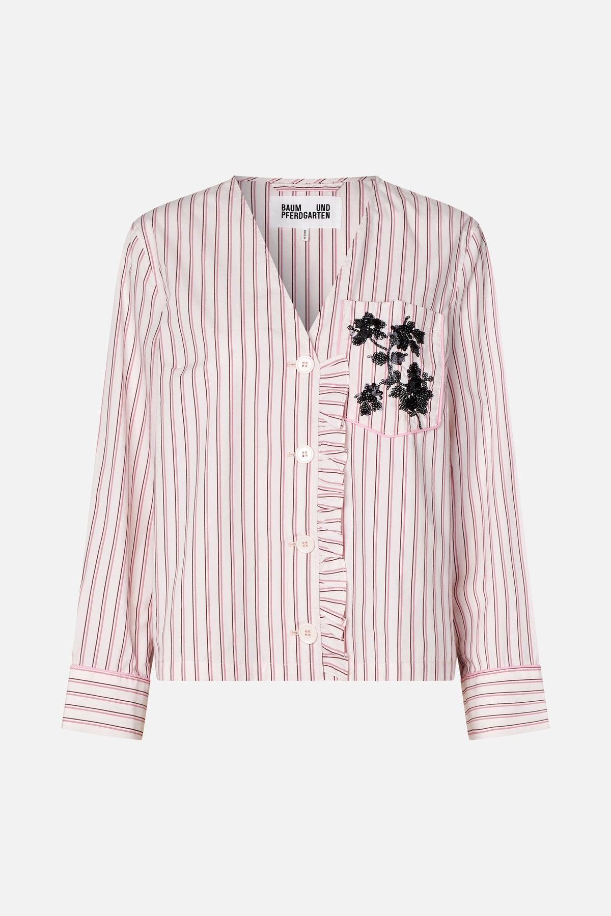 Front view of a cropped white shirt with pink and burgundy stripes, button front, ruffled placket and black sequin floral chest pocket.