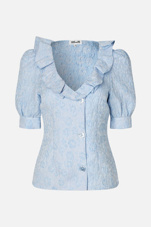 Front view of a pale blue textured floral dress with puff sleeves, a large ruffled collar and front buttons.