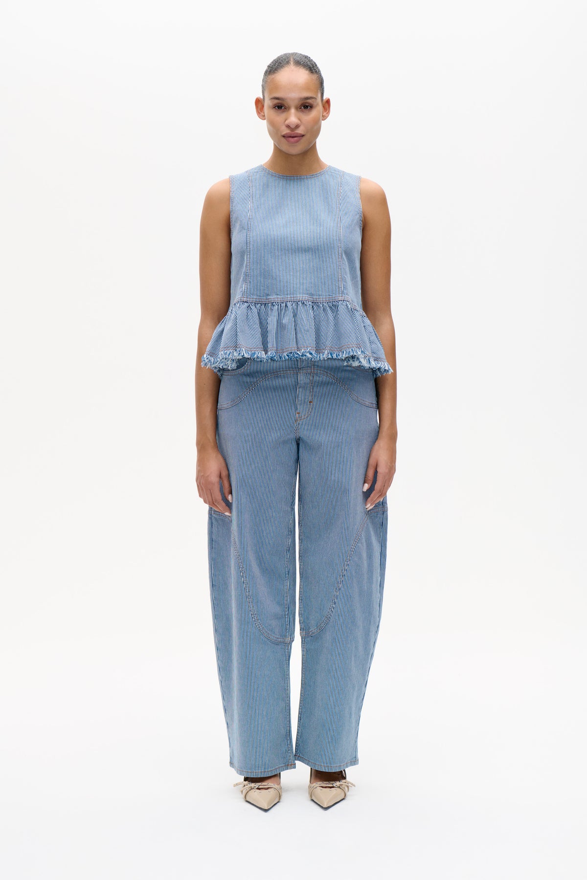 Front view of a blue-and-white pinstripe sleeveless top with a frayed peplum hem, paired with matching wide-leg trousers.