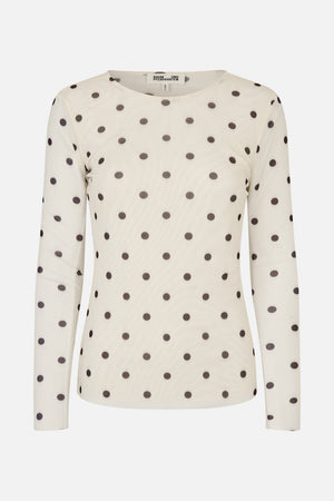 Front view of a cream long-sleeved top with a round neckline and evenly spaced dark polka dots.