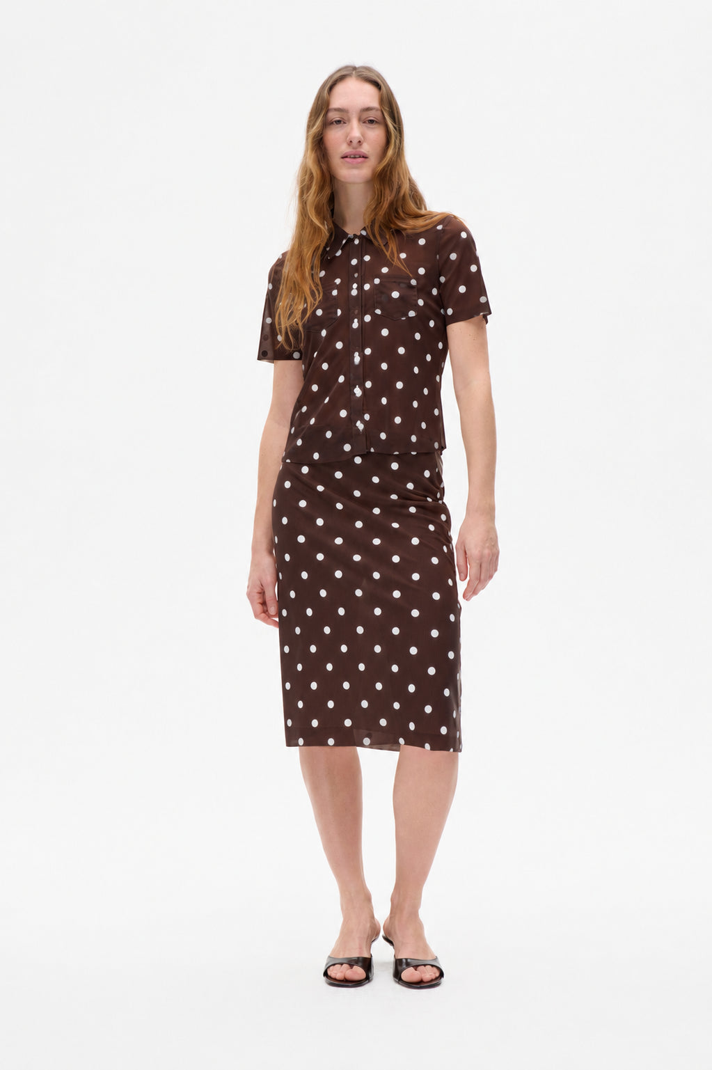 Front view of a brown short-sleeved button-up shirt and knee-length skirt with white polka dots.