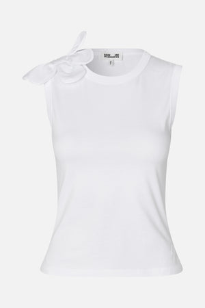 Front view of a white sleeveless top with a round neckline and a large dimensional flower appliqué on one shoulder.
