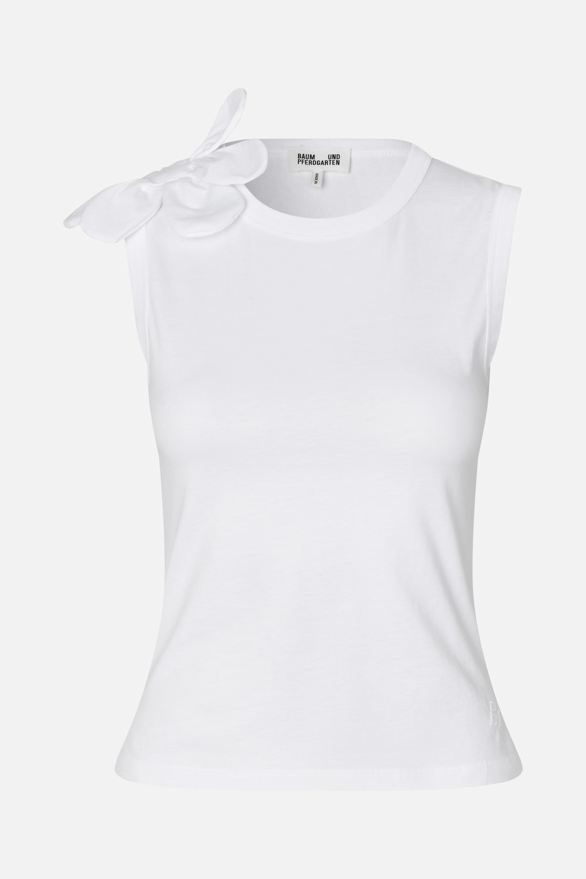 Front view of a white sleeveless top with a round neckline and a large dimensional flower appliqué on one shoulder.