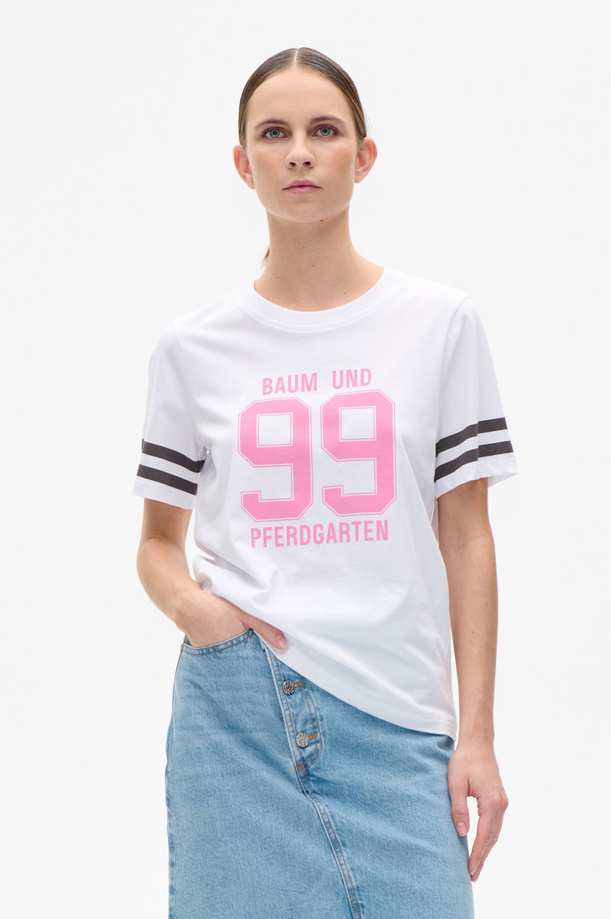 Front view of a white short-sleeve T-shirt with black sleeve stripes and a large pink “89” Baum und Pferdgarten graphic.