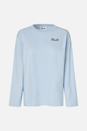 Light blue long-sleeved crew-neck T-shirt with a small black Baum und Pferdgarten logo on the chest, shown from the front.