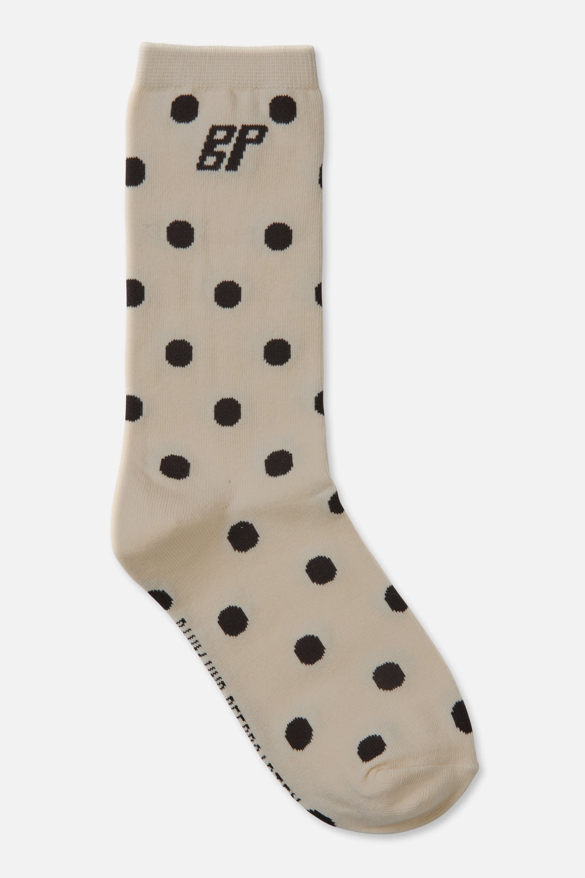 Cream crew sock with black polka dots and a BP monogram near the ribbed cuff, shown at an angle.