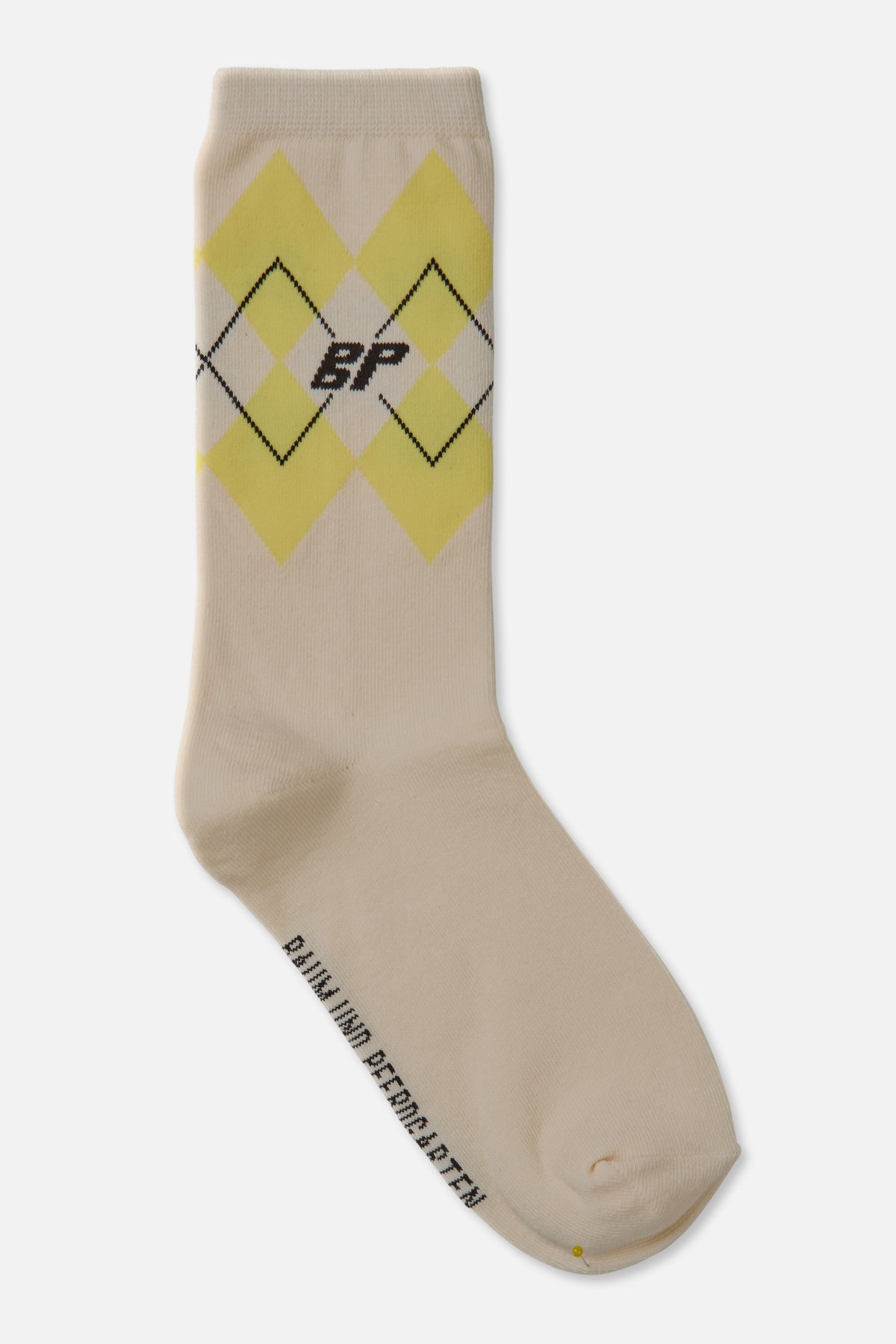 Cream crew sock with pale yellow argyle diamonds, black outlined details and a small monogram, shown diagonally.