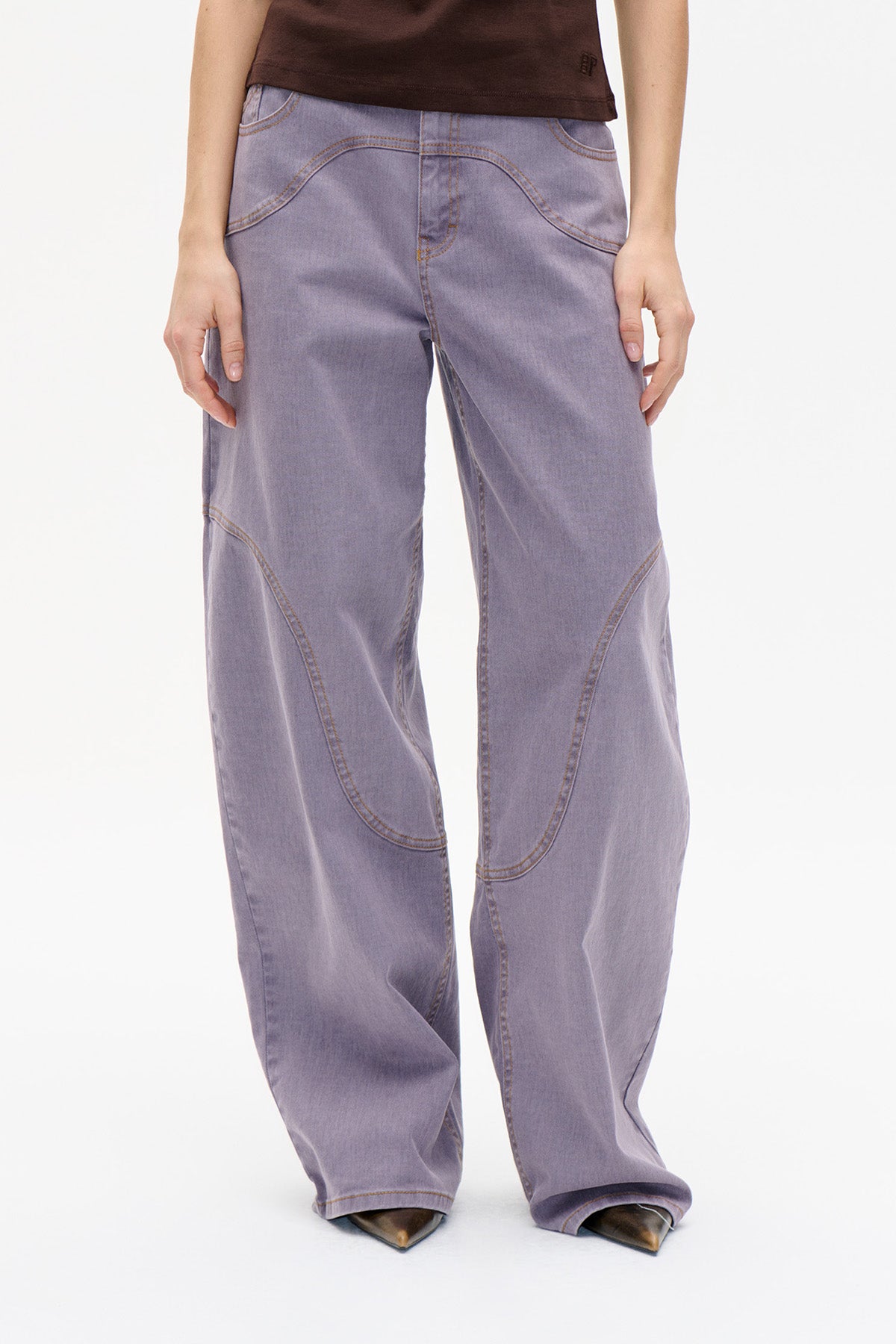Front view of lilac wide-leg jeans with curved contrast stitching and curved front pockets.