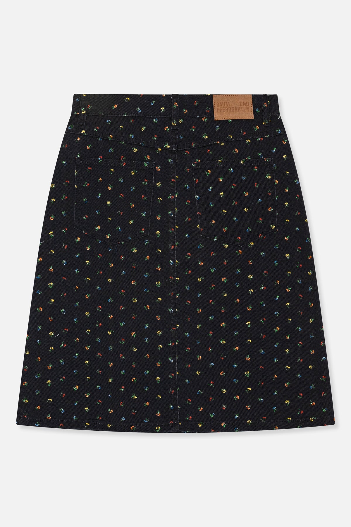 Back view of a black denim skirt with scattered multicolour floral print, two patch pockets and a tan waistband label.