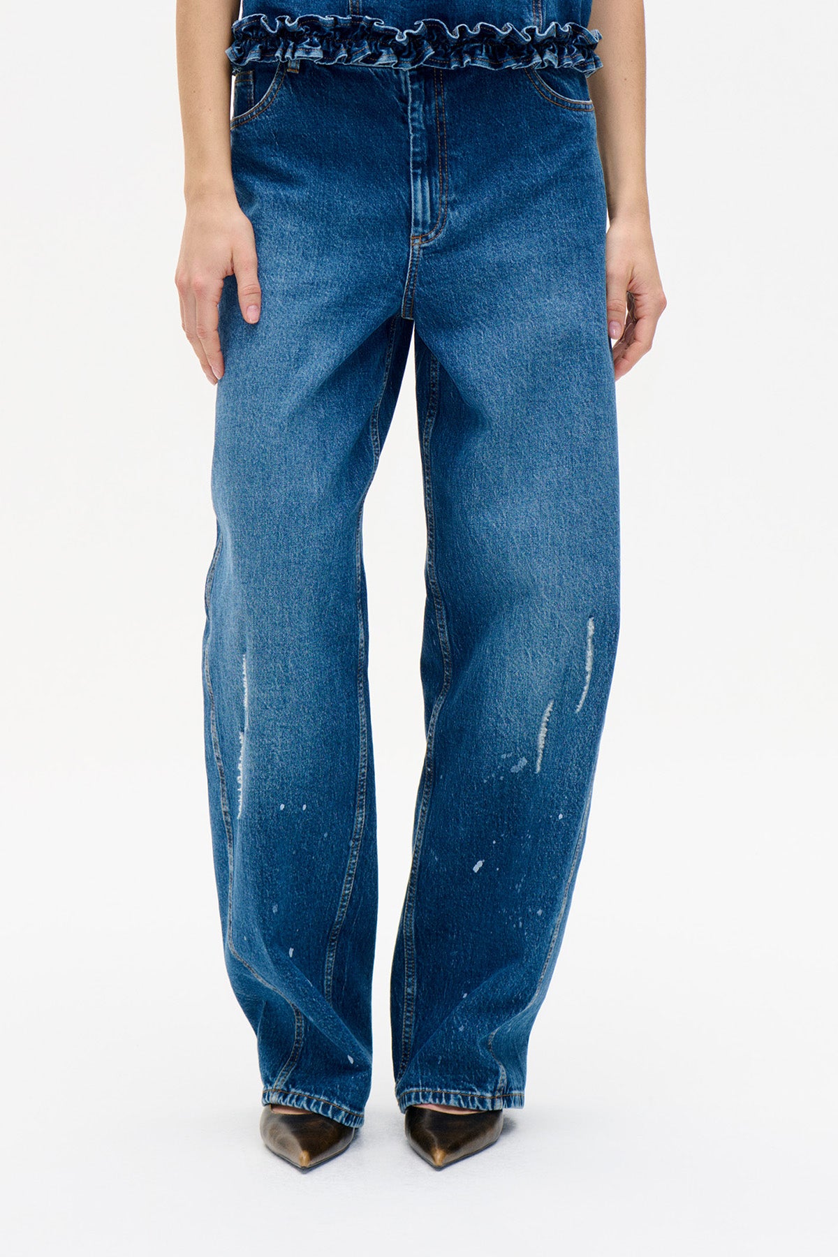 Vooraanzicht van wijde blauwe jeans met lichte slijtage en een gerimpelde denim tailleband