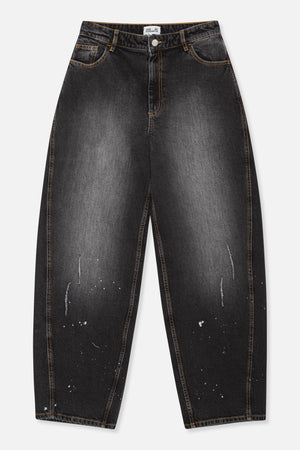 Vooraanzicht van houtskoolzwarte, wijd uitlopende jeans met oranje contraststiksels, vijfzakkenmodel en verspreide witte, verfachtige spatten.