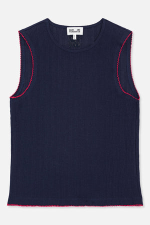Vue de face d'un top sans manches en maille bleu marine, avec un motif de rayures ajourées discret et une bordure festonnée rose vif.