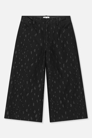 Front view of black wide-leg trousers with an irregular charcoal pattern, button fastening, belt loops and slanted pockets.