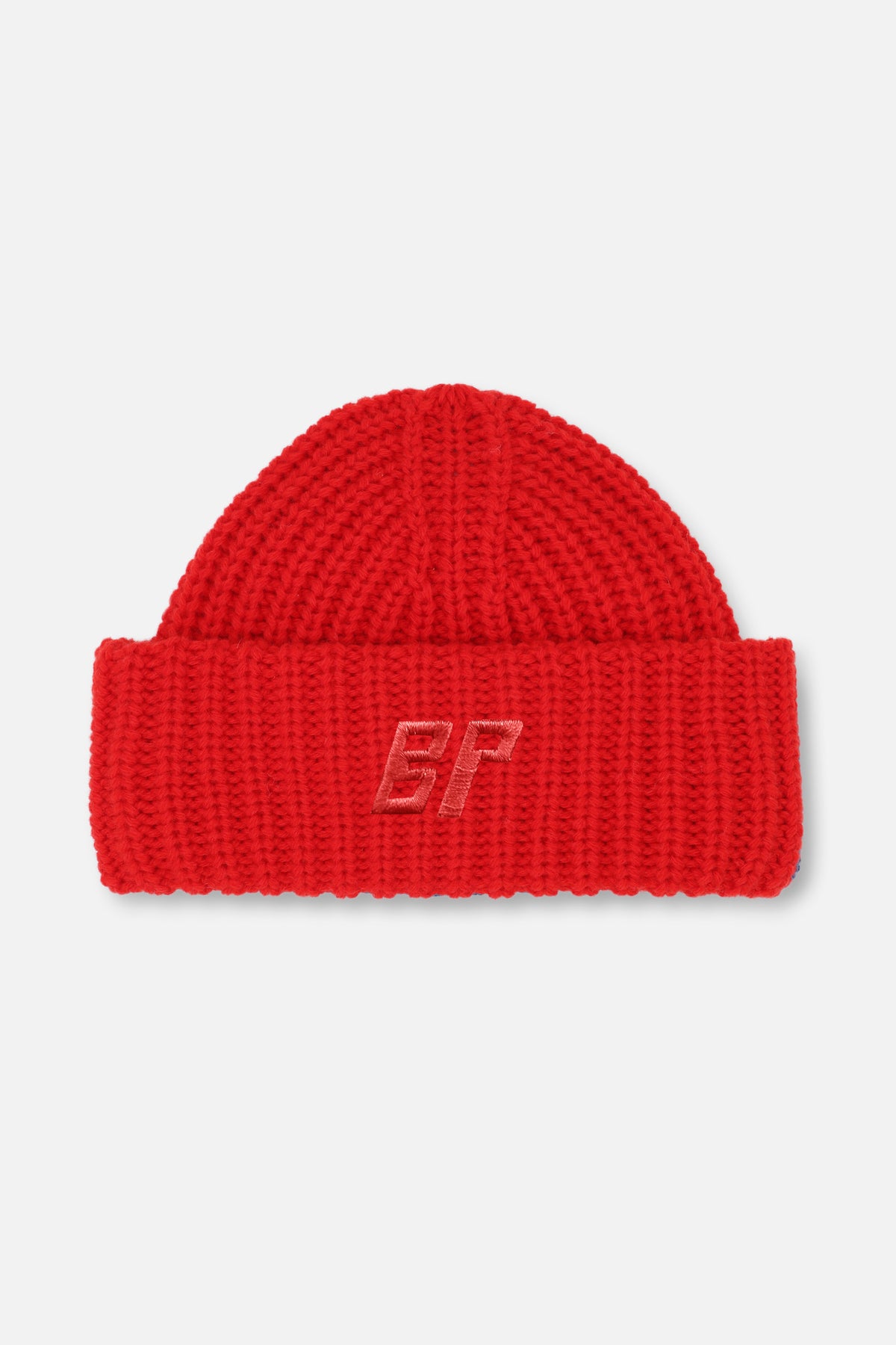 Close-up of a red chunky-knit beanie with a folded cuff and tonal embroidered BP monogram.