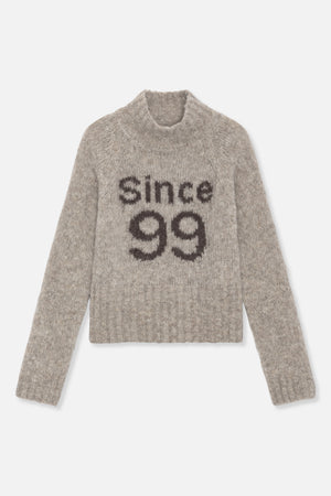 Front view of a fuzzy taupe-grey crew-neck sweater with dark “since 99” lettering across the chest.