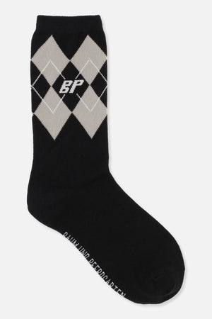 Zwarte kuitlange sok met crèmekleurig argyle-ruitpatroon en klein wit monogram, schuin weergegeven.