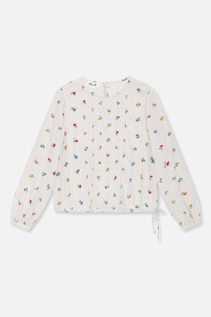 Vooraanzicht van een ivoorkleurige blouse met lange mouwen, verspreide meerkleurige bloemen, verticale plooitjes en een strik in de zoom.