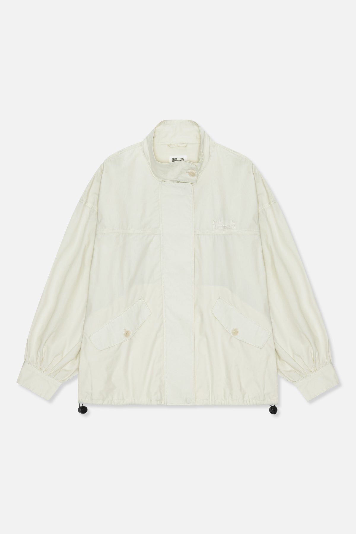 Front view of a light ivory jacket with a high collar, buttoned flap pockets, gathered cuffs and an embroidered chest logo.