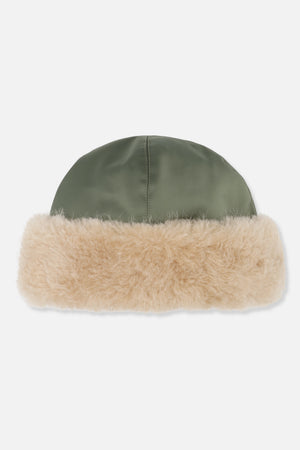 Close-up of an olive green paneled hat with a wide cream fluffy brim.
