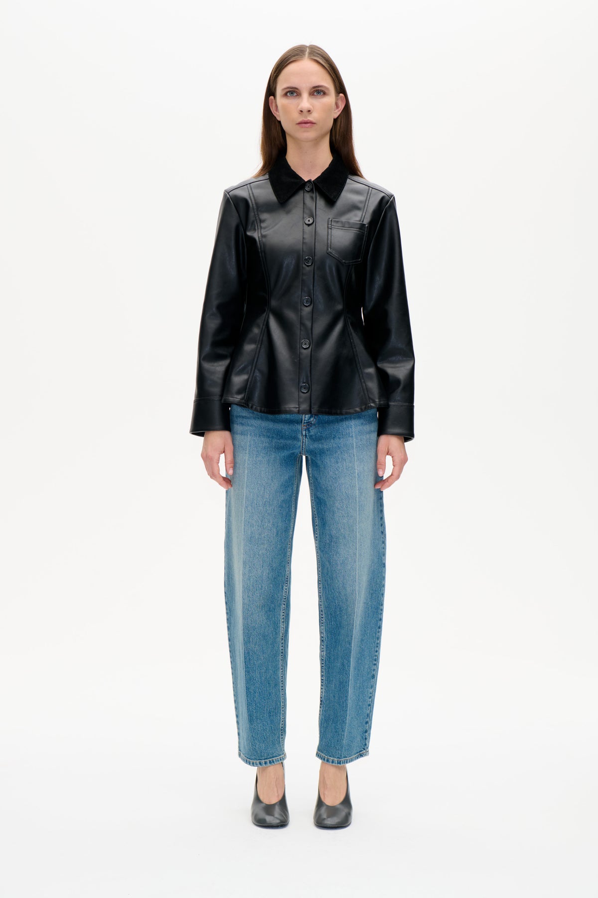 Vue de face d'un mannequin portant une veste noire boutonnée à l'avant, col contrastant et poche poitrine, jean bleu et chaussures noires.