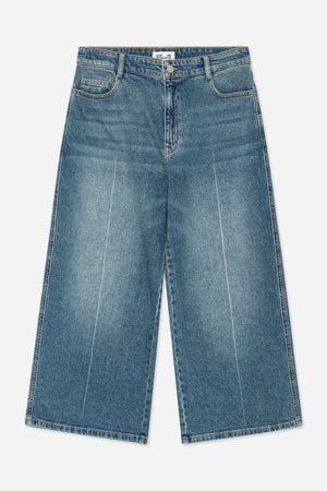Front view of blue washed denim jeans with orange stitching, belt loops, a button fly and curved front pockets.
