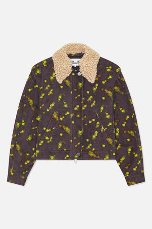 Front view of a dark charcoal denim jacket with scattered yellow-green and orange floral print, angled welt pockets, and a chunky cream textured collar.