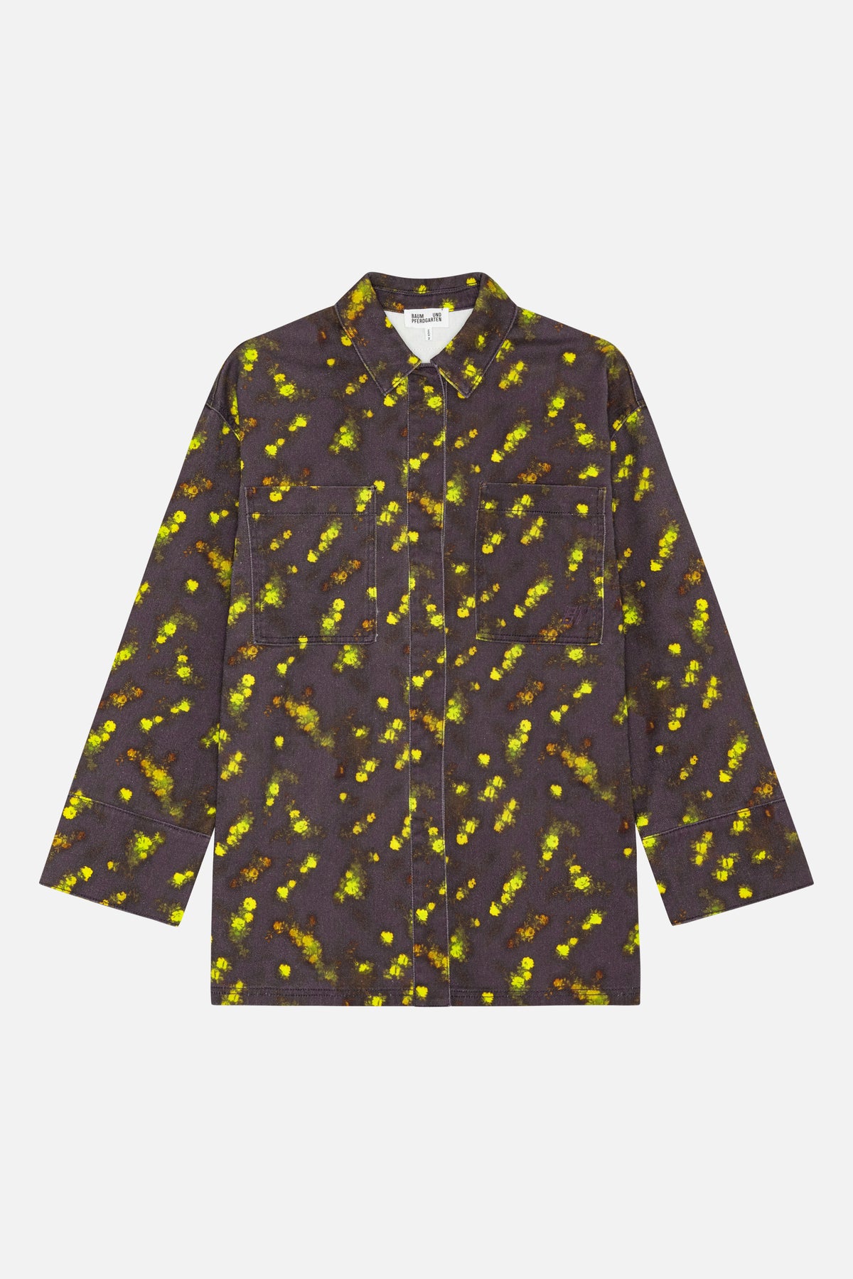 Front view of a long-sleeved collared shirt with two patch pockets, in charcoal fabric with scattered bright yellow and green floral print.