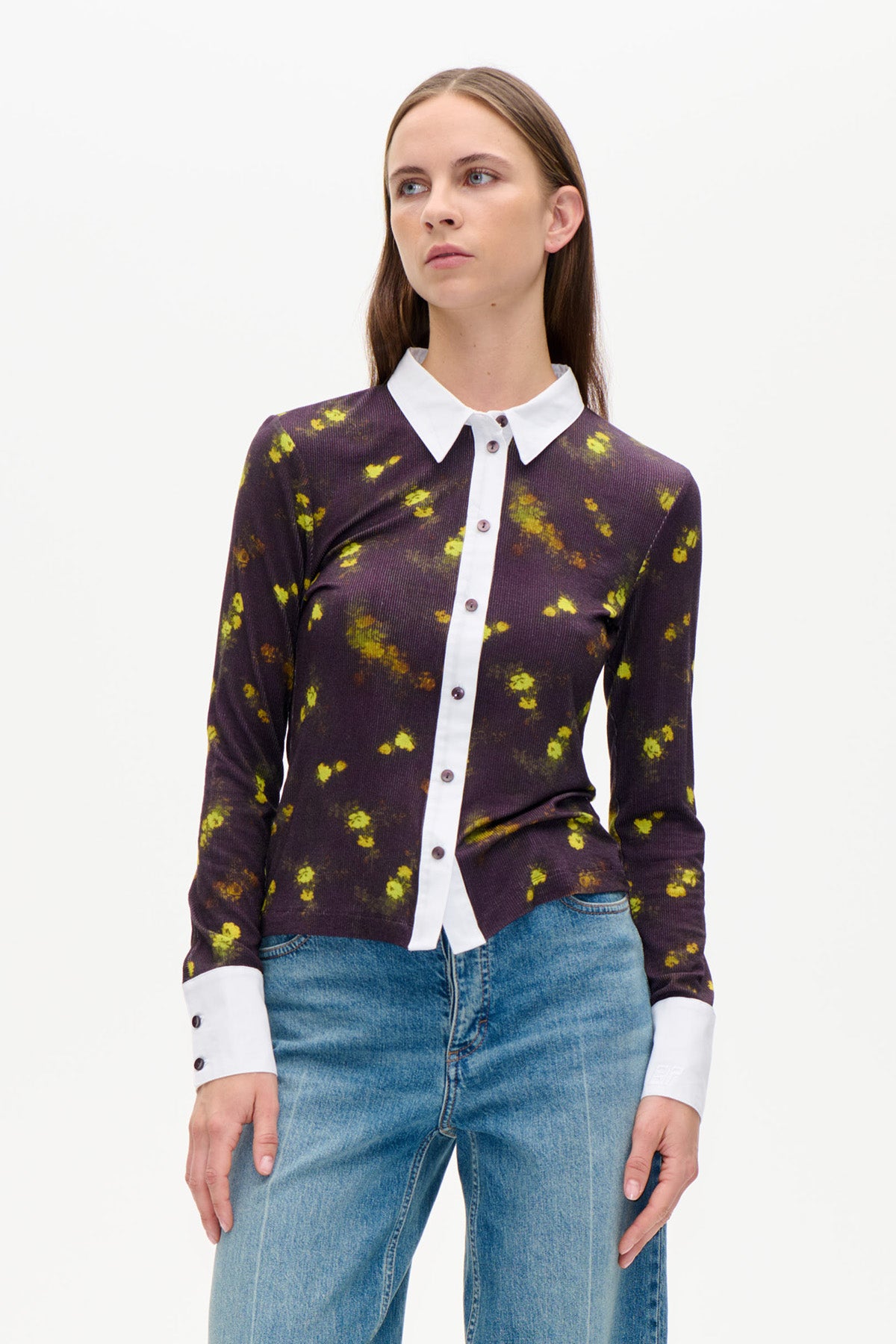 Front view of a dark plum floral button-up cardigan with bright yellow-green flowers, white collar and cuffs, styled with blue jeans.