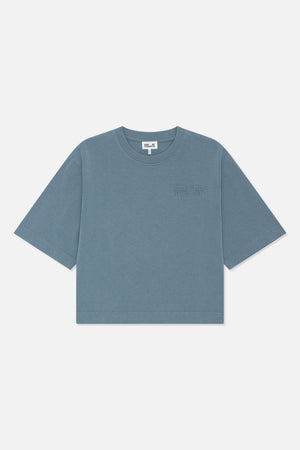 Vorderansicht eines blaugrauen T-Shirts mit kurzen Ärmeln und Rundhalsausschnitt, versehen mit einem dezenten Ton-in-Ton-Logo von Baum und Pferdgarten auf der Brust.